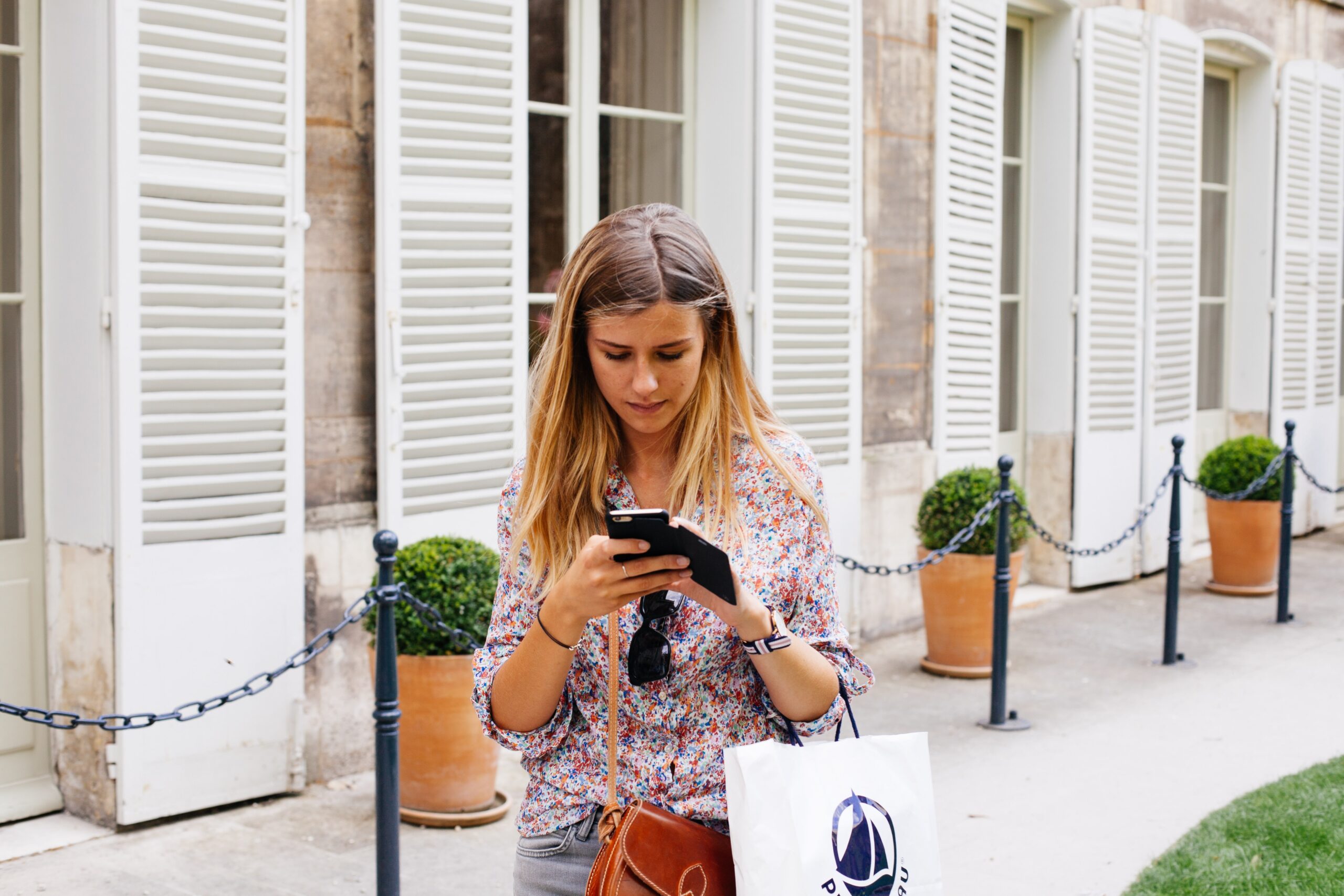 woman looking at phone while out shopping