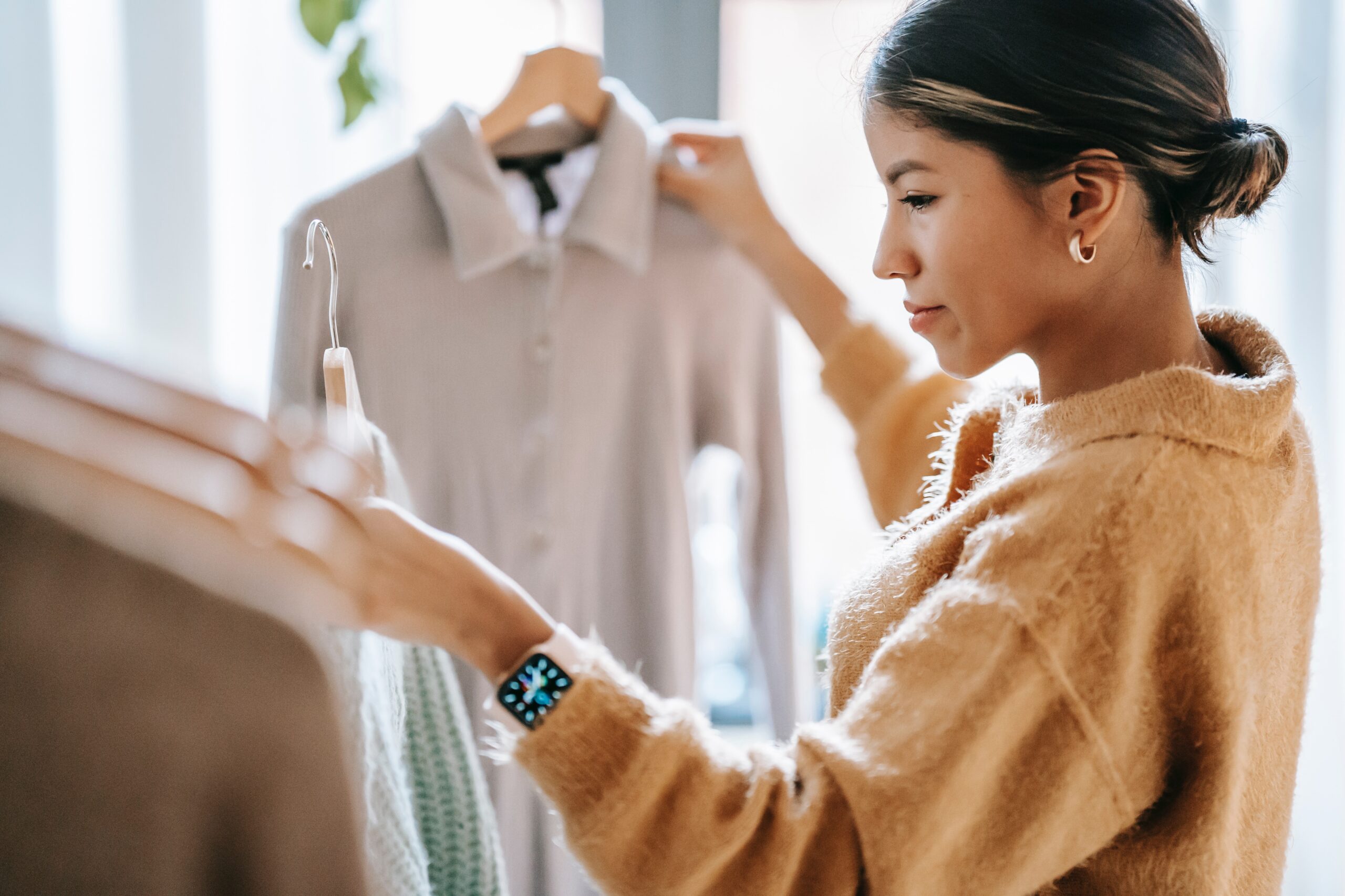 Woman holding up two shirts in an apparel store